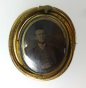 A Victorian pinchbeck memoriam brooch, set with a photographic portrait of a gentleman.