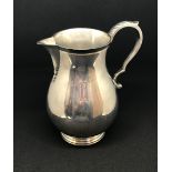 A modern heavy gauge silver and baluster shape jug, marked Goldsmiths and Silversmiths, approx 11.