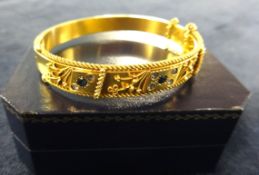 An antique 15ct sapphire and diamond set hinged bangle, 17.40gms (with a copy of an insurance