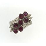 An 18k ruby and diamond fancy set carousel style ring, stamped 18k, white gold set.