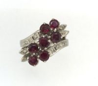 An 18k ruby and diamond fancy set carousel style ring, stamped 18k, white gold set.