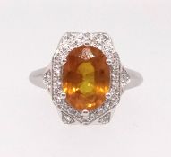A 14k white gold and diamond ring set with an oval cut yellow sapphire, approx 2.80ct, diamonds