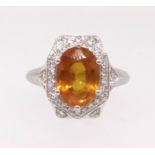 A 14k white gold and diamond ring set with an oval cut yellow sapphire, approx 2.80ct, diamonds