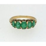 A five stone emerald ring set in yellow gold, finger size O.