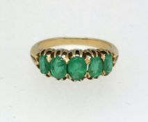 A five stone emerald ring set in yellow gold, finger size O.