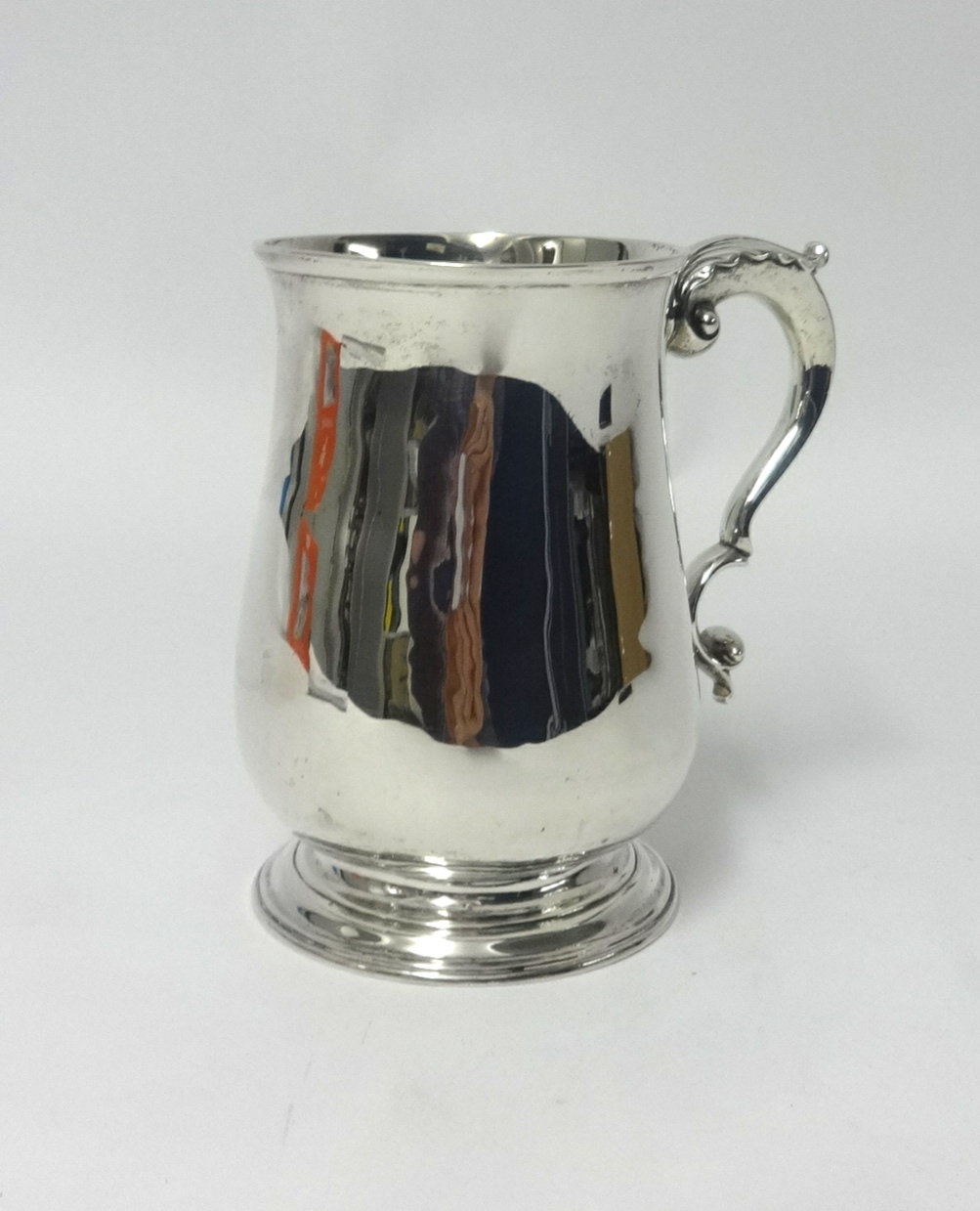 A George III silver and baluster shaped tankard with acanthus decorated scroll handle, underside