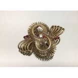 A 9ct gold ruby and diamond set swirl brooch, weight 10.1gms.