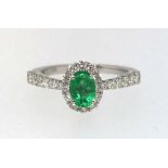 An 18ct emerald and diamond set ring.