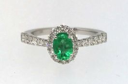 An 18ct emerald and diamond set ring.