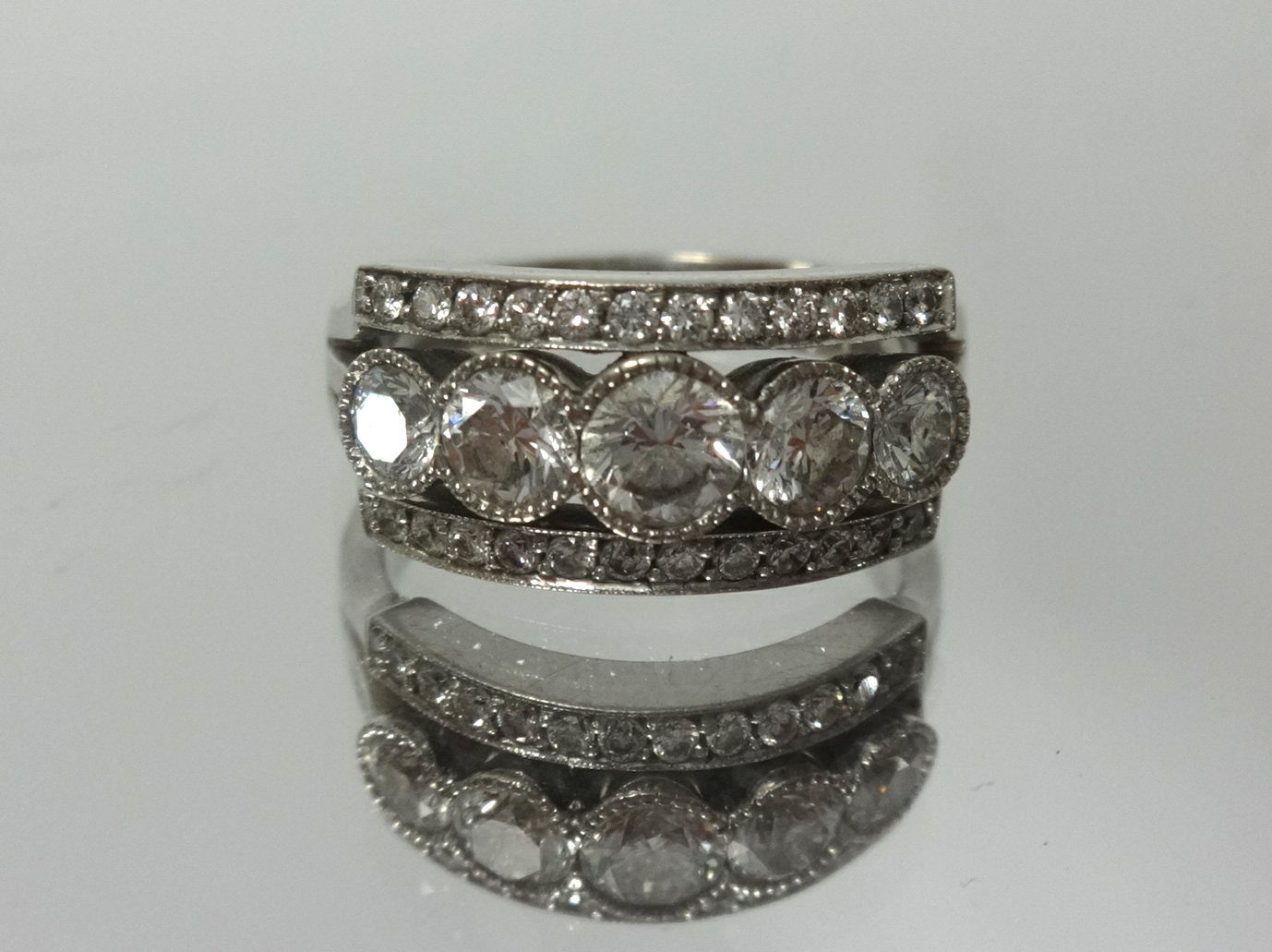 An 18ct white gold channel set diamond ring, finger size L.