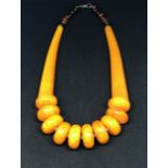 A 'yellow' amber style necklet and a red amber style graduated bead bracelet (2).