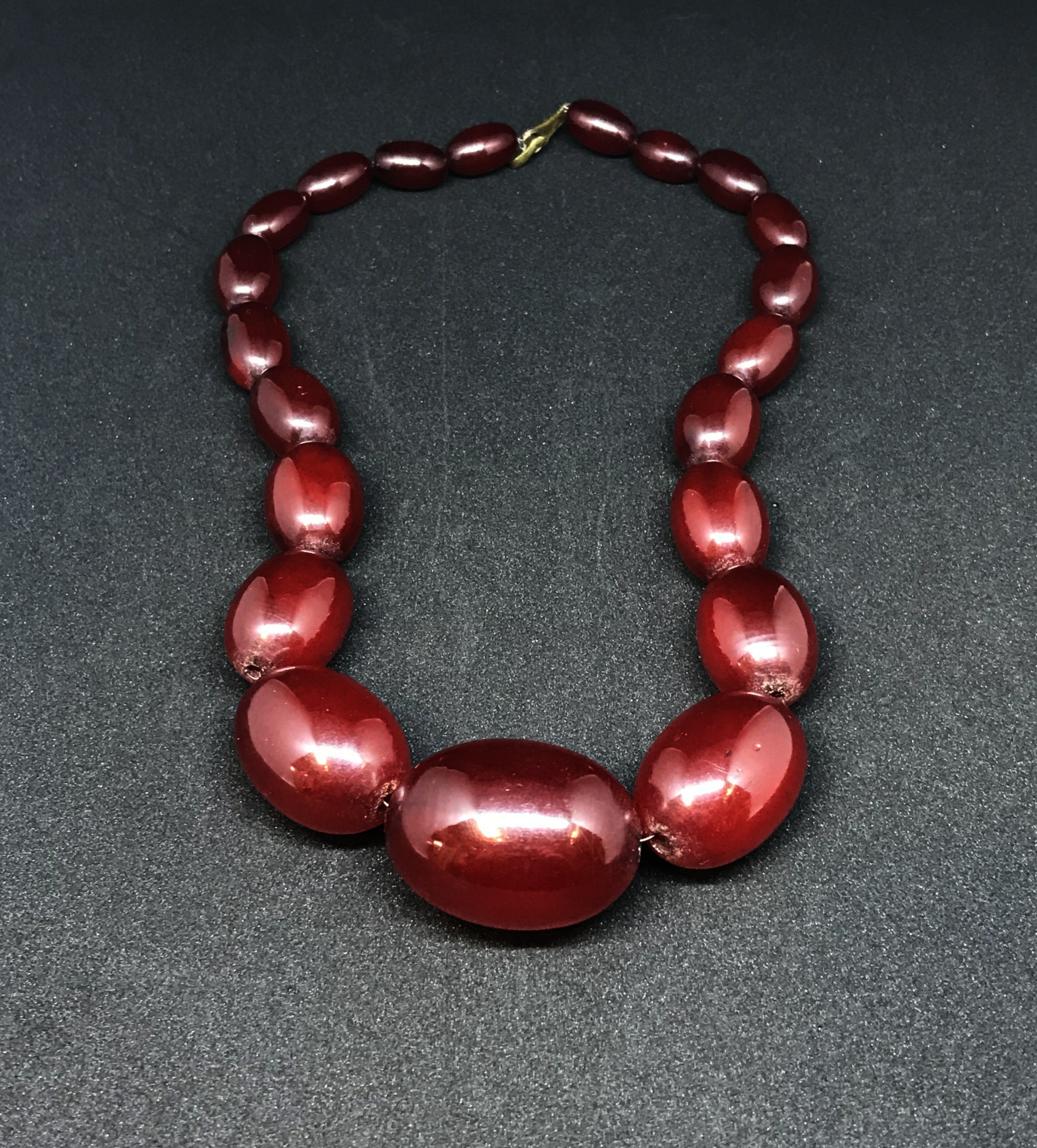 A red amber necklace of graduated beads, the largest approx 24mm diameter, weight 70gms.