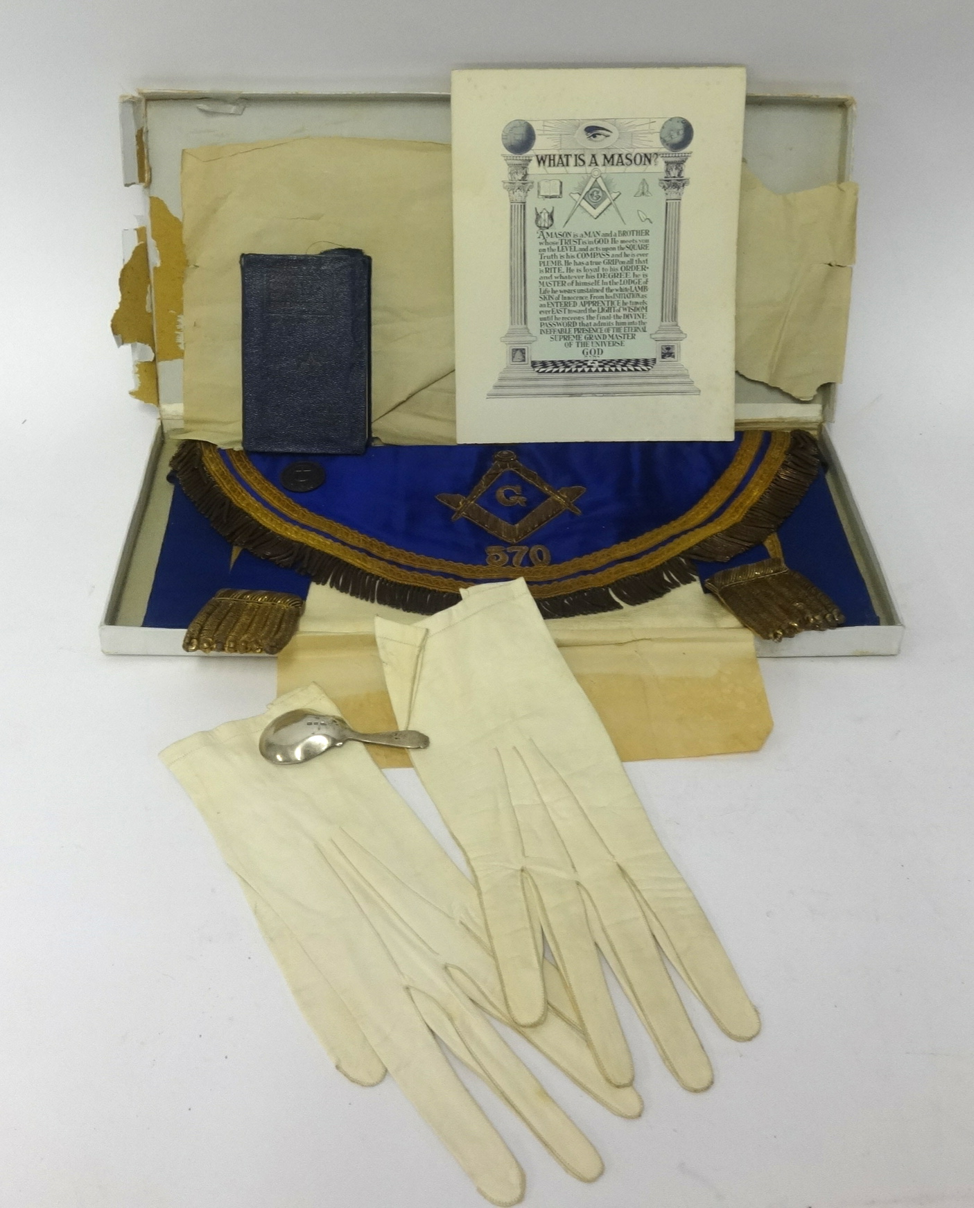 Of Masonic interest, an apron, gloves, booklet and also a silver caddy spoon.