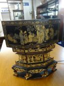 An Oriental lacquered table lamp, with gilt carvings and decoration.