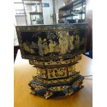 An Oriental lacquered table lamp, with gilt carvings and decoration.