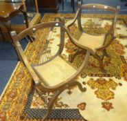 A pair of oak framed and caned seated elbow chairs of Italian 'X' frame style.