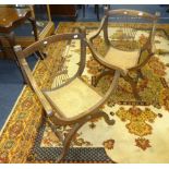 A pair of oak framed and caned seated elbow chairs of Italian 'X' frame style.