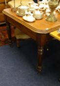 Victorian mahogany dining table with turned legs and brass castors, 106cm x 106cm.