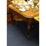 Victorian mahogany dining table with turned legs and brass castors, 106cm x 106cm.