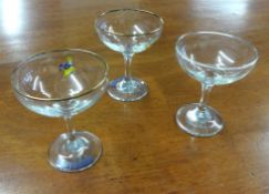 A collection of thirteen Babycham glasses.