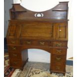 An oak arts and crafts style desk with carved three quarter gallery, full front and fitted