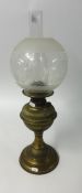 An antique brass oil lamp with etched globular shade and funnel, maximum height 54cm.