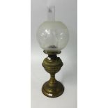 An antique brass oil lamp with etched globular shade and funnel, maximum height 54cm.