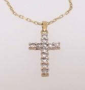 A diamond set yellow gold cross, stamped 18k, on a fine 18k gold chain.
