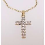 A diamond set yellow gold cross, stamped 18k, on a fine 18k gold chain.