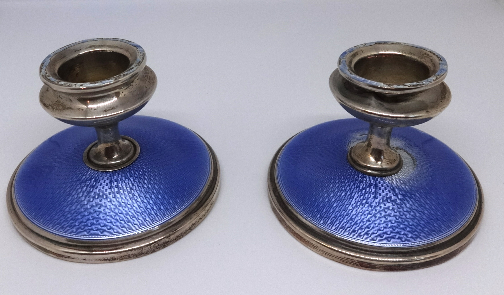 A pair of small silver and enamelled candlesticks, height 5.50cm.