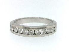 A modern 14ct white gold gents channel set half band ring containing nine round diamonds, total