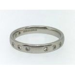 A platinum wedding band set with nine small diamonds, approx 4.5gms, ring size M.