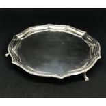 A Geo V sterling silver salver with paw feet and a ribbon and bow leaf design border, makers mark 'G