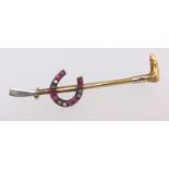 An early 20th century ruby and diamond set brooch modelled as a horseshoe and riding crop,