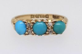 An 18ct three stone turquoise ring set with four small diamonds, ring size N.