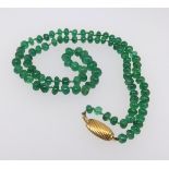 A string of emerald beads with 18ct gold snap.