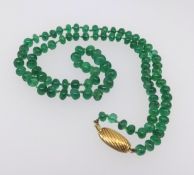 A string of emerald beads with 18ct gold snap.