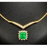 A fine emerald and diamond cluster drop pendant set in 18ct yellow gold attached to a herringbone
