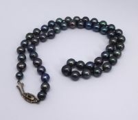 A single uniform row of grey/black cultured Tahitian, South Sea pearls, approx 7mm, together with