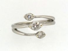 A modern diamond three stone ring, the centre round brilliant cut stone approx 0.30ct, two further