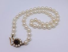 A single uniform row of culture pearls set with an oval garnet and pearl snap circa 1975, approx