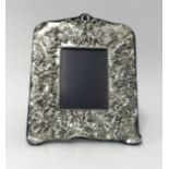 A Britannia silver rectangular heavy embossed photo frame, the wide border depicting cherubs with