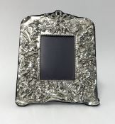 A Britannia silver rectangular heavy embossed photo frame, the wide border depicting cherubs with