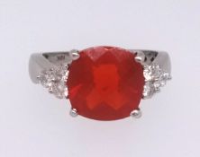 A Mexican fire opal ring set with nine further round cut diamonds in white gold, stamped
