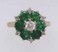 An 18ct emerald and diamond cluster ring, ring size K.