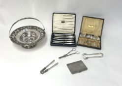 A silver plated cake basket, cigarette case, grape scissors, tongs also a cased set of six silver