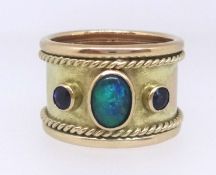A 9ct gold thumb ring set with two ceylon sapphires and an opal, commissioned and produced by Crazy