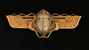 An antique gold Egyptian Revival brooch set with a carved hardstone scarab indistinctly marked,