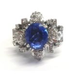 A fine Burmese sapphire ring set in white gold, unmarked, of a flower design set with diamonds (