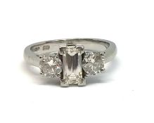 A good modern platinum three stone diamond ring, with a centre step cut diamond, weighing approx 0.